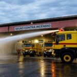 Bastidores da Segurança Quem são os bombeiros que protegem o Aeroporto de Navegantes Quando o alarme de emergência soa no terminal do Aeroporto Internacional de Navegantes, o relógio passa a ser o principal adversário. Em apenas 40 segundos, a equipe precisa vestir equipamentos que pesam cerca de 25 quilos, embarcar nas viaturas e acelerar. A missão é clara e cirúrgica chegar a qualquer ponto operacional da pista ou do terminal em, no máximo, 2 minutos e 10 segundos. O objetivo final Garantir que nenhuma resposta passe dos 3 minutos. Preparação diária consome 10 mil litros de água reutilizável Para que essa engrenagem funcione sem falhas, a rotina é marcada pela repetição e pela precisão. Todos os dias, os caminhões de combate a incêndio passam por dois testes operacionais rigorosos. Cada procedimento utiliza cerca de 5 mil litros de água para garantir que os canhões e sistemas estejam prontos. Sustentabilidade na pista Toda a água utilizada nesses testes diários é direcionada para um sistema de reuso e reaproveitada posteriormente, evitando o desperdício. Por trás desse padrão de excelência está a SESCINC (Seção Contra Incêndio) do aeroporto. O grupo é formado por 40 bombeiros de aeródromo que se dividem em quatro turnos ininterruptos, cobrindo o terminal 24 horas por dia na prevenção, salvamento e combate a incêndios aeronáuticos. Movimentação recorde exige atenção redobrada A responsabilidade da equipe cresce na mesma proporção do aeroporto. Administrado pela CCR Aeroportos, o terminal de Navegantes encerrou o ano de 2025 com mais de 2,3 milhões de passageiros, consolidando-se como o segundo aeroporto mais movimentado do Brasil fora das capitais. O ritmo continua acelerado apenas no primeiro trimestre de 2026, o terminal registrou aproximadamente 590 mil viajantes entre embarques e desembarques — um crescimento de 6% em relação ao mesmo período do ano passado. 2,3 milhões de passageiros em 2025. 590 mil viajantes no 1º trimestre de 2026. Alta de 6% no fluxo de passageiros no início deste ano. Além de lidar com a segurança dos voos, os bombeiros atuam fortemente na prevenção diária. Uma das ocorrências mais comuns na rotina é a captura e remoção de fauna (animais de pequeno e médio porte) nas proximidades da pista, um trabalho essencial para evitar colisões durante pousos e decolagens. O trabalho invisível aos olhos dos passageiros Quem passa pelo terminal rumo às férias ou ao trabalho geralmente não imagina o que acontece nos bastidores. Quando não estão em atendimento direto, os bombeiros passam o dia em treinamentos técnicos, simulados operacionais, testes de condicionamento físico, estudos de cenários e caminhadas de inspeção na área de manobras. Em um aeroporto com a movimentação de Navegantes, a segurança operacional exige preparo contínuo e resposta imediata. Existe toda uma estrutura trabalhando de forma integrada para garantir que o aeroporto opere com segurança e eficiência em qualquer situação, destaca Wilson Rocha, gerente do Aeroporto Internacional de Navegantes. Supercaminhões e roupas de alta tecnologia A estrutura da SESCINC conta com três viaturas aeroportuárias de alta tecnologia, desenvolvidas especificamente para o ambiente de aviação. Juntos, esses supercaminhões têm capacidade para transportar 33 mil litros de água; Espuma especial (LGE) para contenção de chamas; Pó químico específico para combate a incêndios com combustível de aviação (Querosene de Aviação - QAV). Para enfrentar o calor extremo de um eventual incêndio, os profissionais utilizam roupas aluminizadas de aproximação, sistemas de proteção respiratória autônoma e ferramentas de desencarceramento pesado. Graças à memória muscular dos treinos, eles vestem todo o traje de 25 kg em menos de um minuto. Treinamento específico e regras da ANAC Diferente dos bombeiros convencionais, os bombeiros de aeródromo passam por uma formação altamente especializada. O foco total é a evacuação rápida de aeronaves de grande porte, isolamento de combustível espalhado na pista e gerenciamento de pânico em áreas restritas. Toda a rotina e os exercícios práticos seguem normas rígidas da ANAC (Agência Nacional de Aviação Civil). Muita gente acredita que o bombeiro passa o dia esperando uma ocorrência acontecer. Na realidade, quando não estamos atendendo uma emergência, estamos treinando, testando equipamentos, revisando procedimentos e aperfeiçoando técnicas, explica Gustavo Aurélio Costa, gerente de seção da equipe de bombeiros de aeródromo. É essa preparação diária que permite que a equipe responda com rapidez e eficiência quando cada segundo faz diferença.